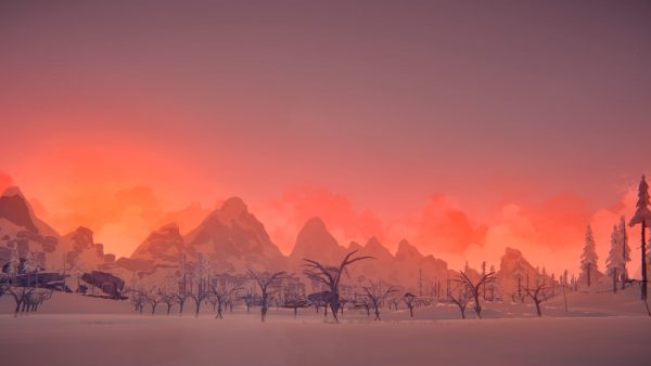 A vibrant sunset, with distant mountains in the background and frostbitten trees in the foreground.